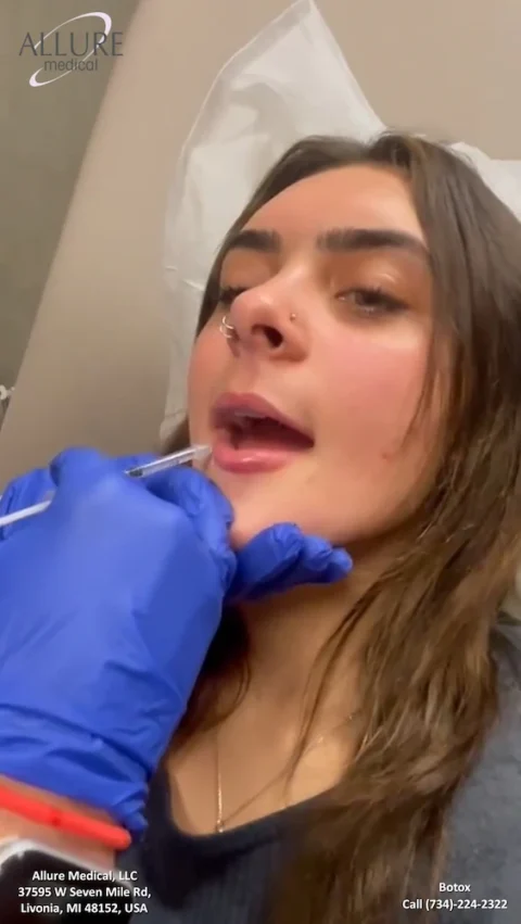 A person receiving Botox injections in their lips at a medical clinic. Text on the image includes the clinic’s name, address, and contact information.