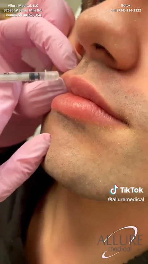 A medical professional in pink gloves administers an injection to a person's lips. The image contains text details of a medical clinic and their contact information.