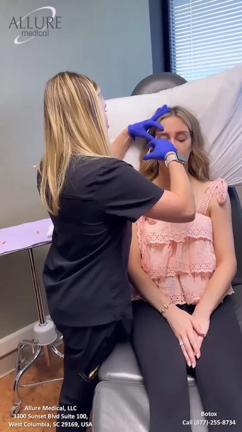 A woman receives a Botox injection on her forehead from a healthcare professional wearing gloves at Allure Medical, LLC in West Columbia, SC. Contact information is visible at the bottom.