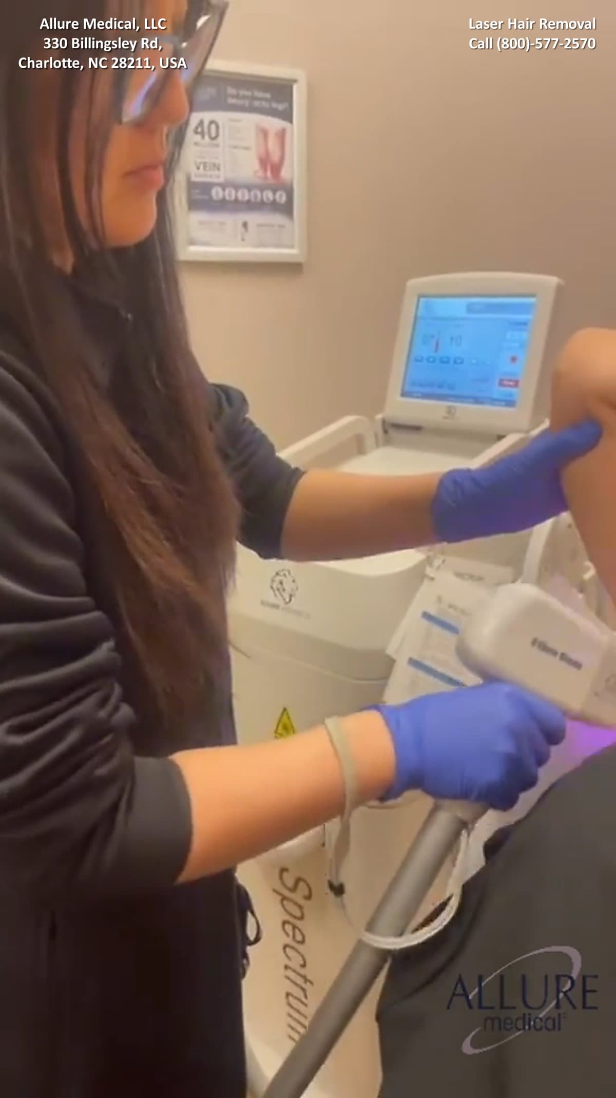 A person with long hair and glasses uses a laser hair removal device on another person's underarm in a clinical setting at Allure Medical, LLC in Charlotte, NC. Information and branding are visible.