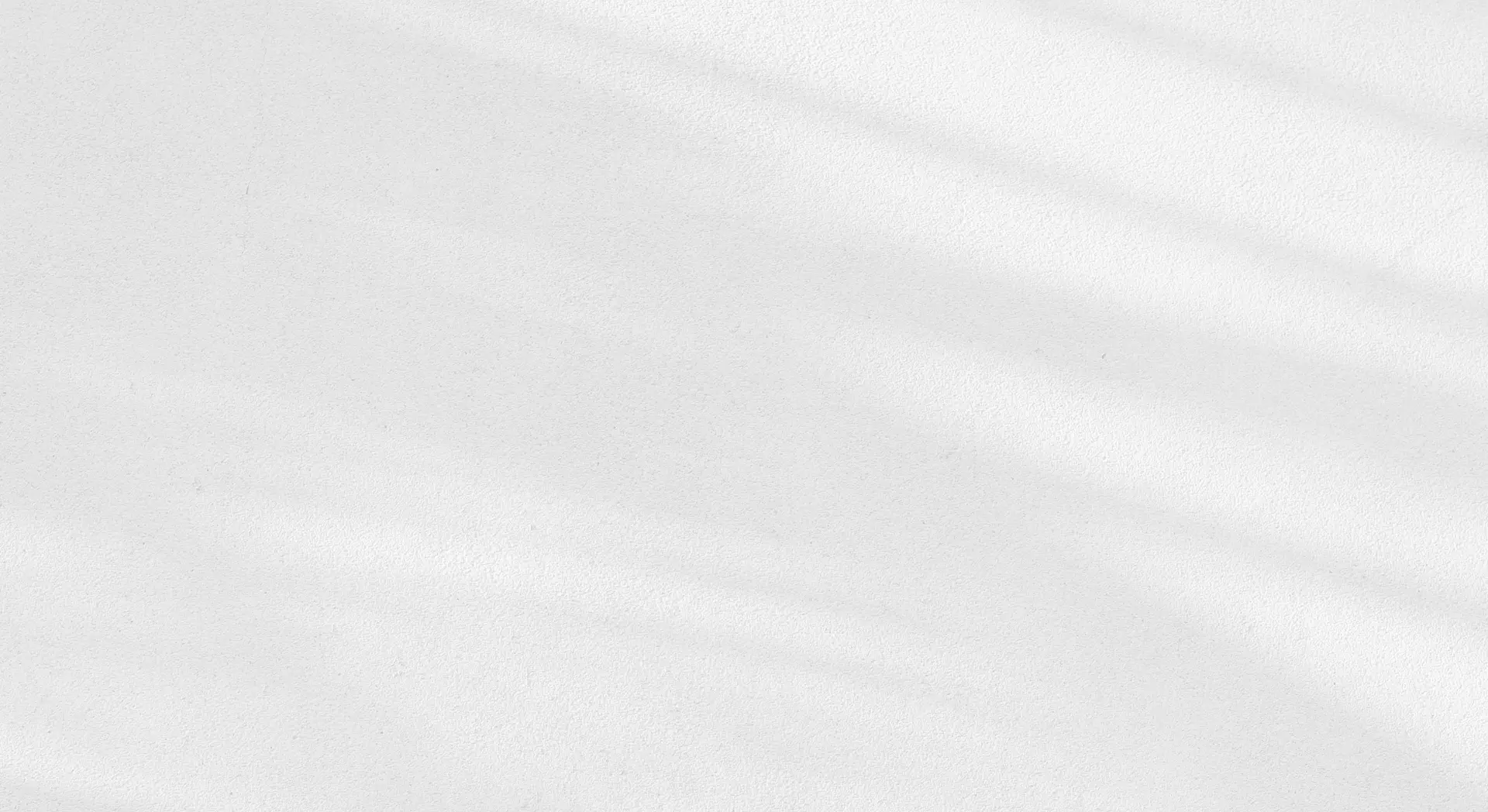 A plain white textured surface with subtle diagonal shadows.