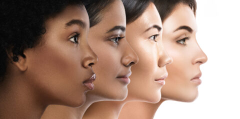 Four women of diverse ethnic backgrounds are shown in profile, facing right, against a white background. Their skin tones range from dark to light.